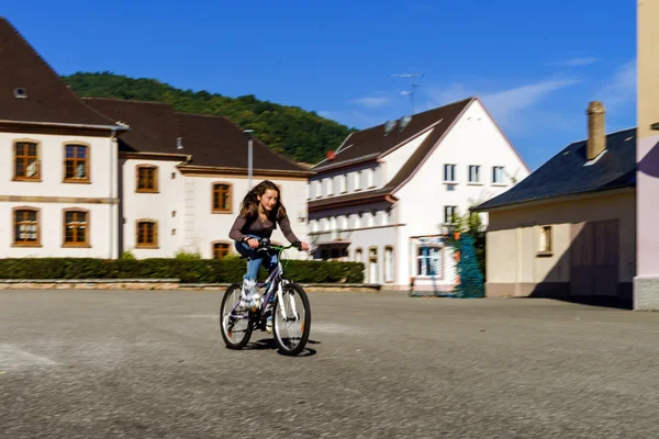 Adolescente bicyclette en bottes à roulettes. Vitesse de tir — Photo