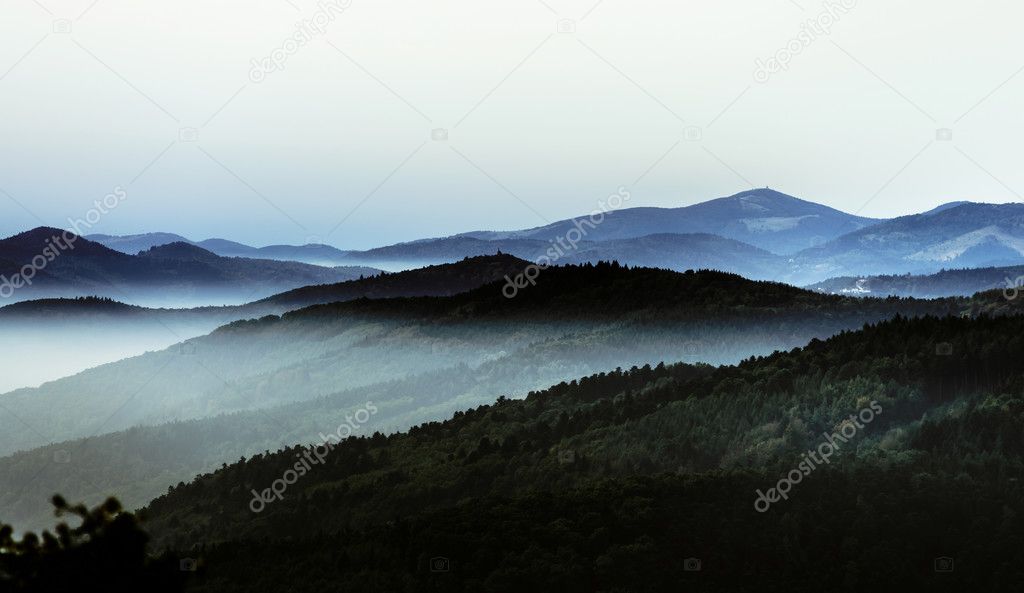 Beautiful mountains landscape from the top of the hill with fog