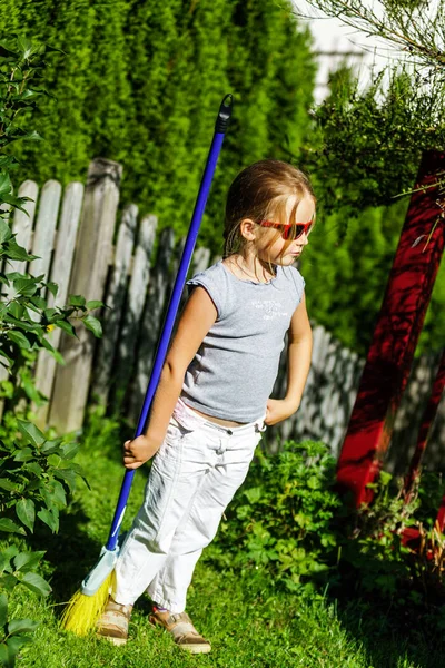 Nettes kleines Mädchen hilft Mutter im Garten — Stockfoto