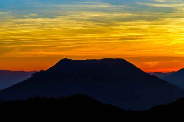 Idyllic sunset landscape with silhouettes of mountains and vivid — Stock Photo, Image