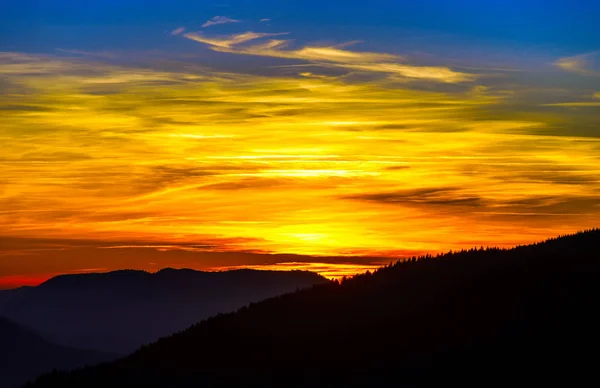 Paisaje idílico al atardecer con siluetas de montañas y vívidas — Foto de Stock