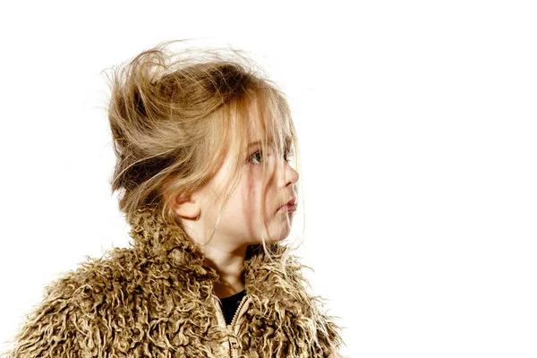 Disheveled preschooler girl with long hair dressed in fur coat — Stock Photo, Image