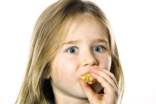 Kleine meisje eten Mandarijn, close-up weergave — Stockfoto