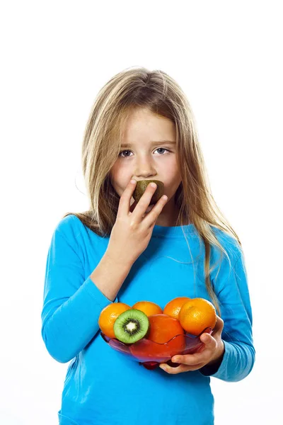 Söt liten flicka med tallrik frukt: kiwi, datum plommon, mandarin — Stockfoto