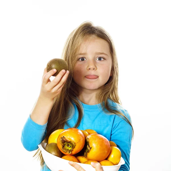 Gadis kecil yang lucu dengan sepiring buah-buahan: kiwi, plum kencan, mandarin — Stok Foto