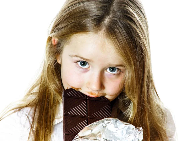 Cute little girl eating tablet of chocolate — Stock Photo, Image