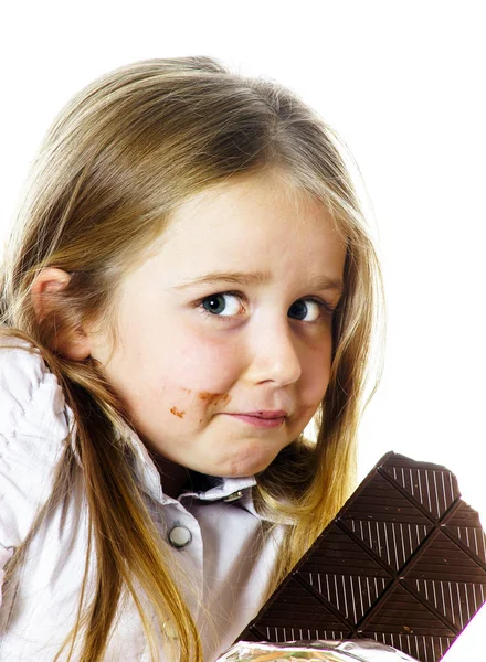 Sevimli küçük kız tablet çikolata yeme — Stok fotoğraf