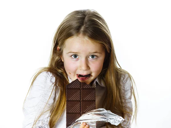 Cute little girl eating tablet of chocolate — Stock Photo, Image