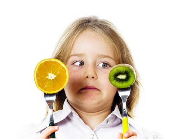 Grappige meisje selecteren tussen kiwi en sinaasappel — Stockfoto