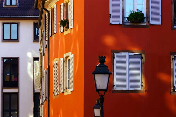 Красная стена дома с красивыми окнами и ставнями — стоковое фото