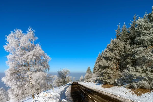 Dağlarda kış yol. Donmuş ağaçlar ve mavi gökyüzü. Güneşli d — Stok fotoğraf