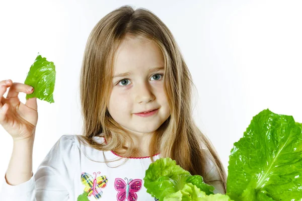 Söt liten flicka poserar med färska salladsblad — Stockfoto