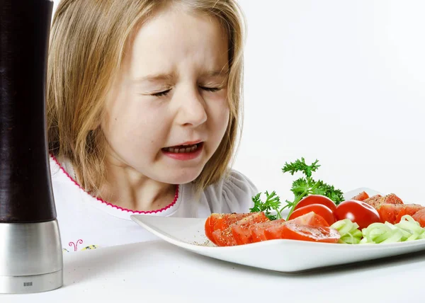 Schattig klein meisje met salade en peper doos — Stockfoto