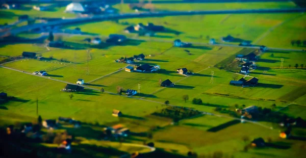 Miniaturní pásové letecký pohled na obec v Alpách — Stock fotografie