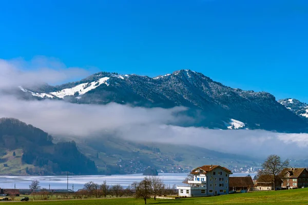 Paesaggio naturale alpino con campi verdi, alte rocce e bianco — Foto Stock