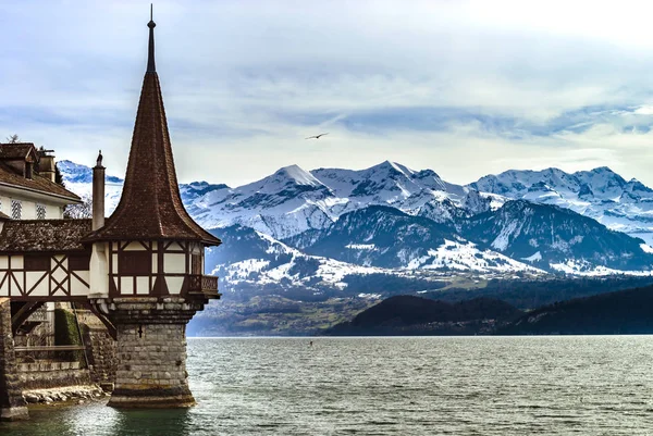 Oberhofen castle tower on alpine background, mountains with snow — Stock Photo, Image