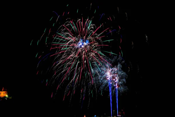 Longa exposição de fogos de artifício multicoloridos contra um céu negro — Fotografia de Stock