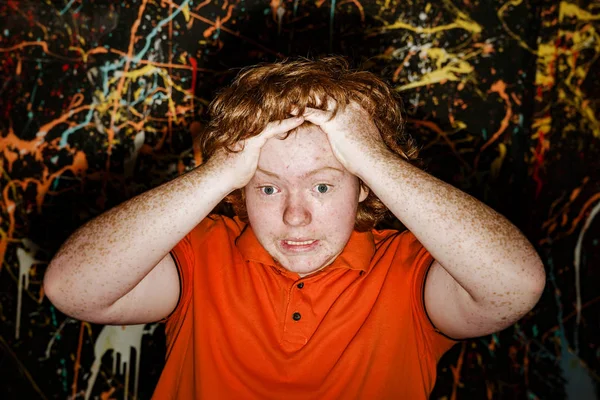 Red-haired boy taking his head showing catastrophe situation — Stock Photo, Image