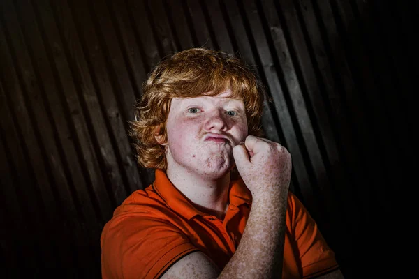 Red-haired boy showing biceps with threaten face — Stock Photo, Image