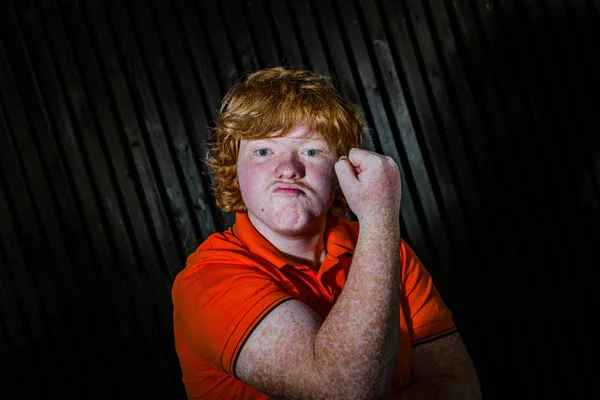 Rudowłosa chłopiec Wyświetlono biceps z twarzy grozić — Zdjęcie stockowe