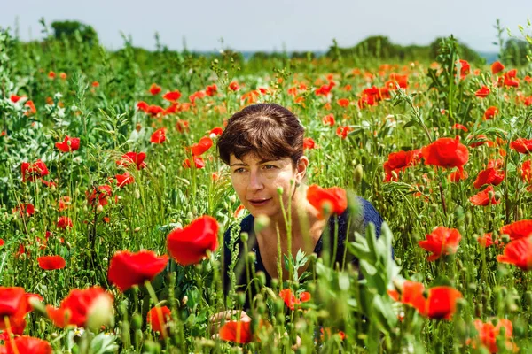 Genç kadın kırmızı haşhaş alanında poz