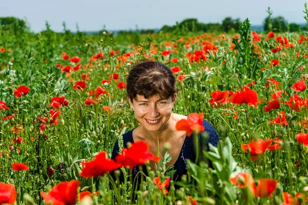 Genç kadın kırmızı haşhaş alanında poz