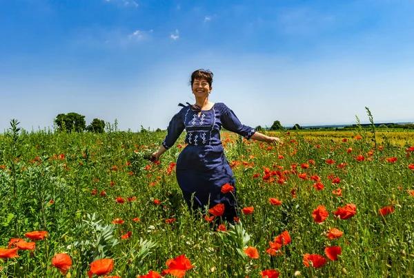 Giovane donna in posa in campo papaveri rossi — Foto Stock