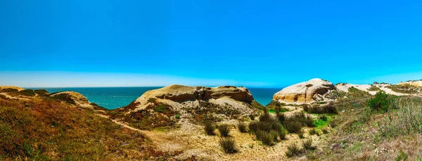 Желтые скалы и песок на португальском побережье, живая океаническая вода — стоковое фото