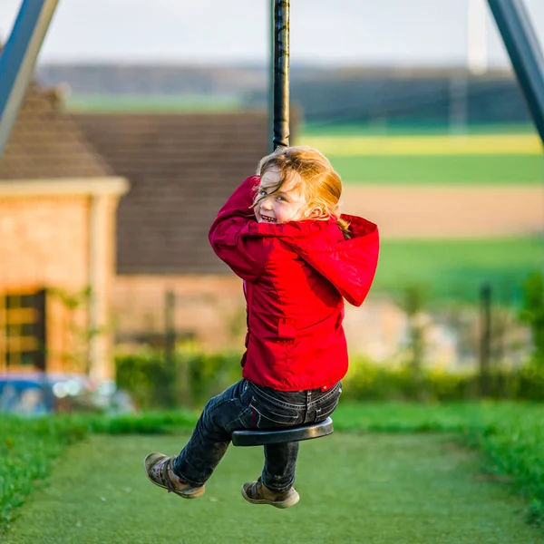 Nettes kleines Mädchen spielt auf Kinderspielplatz — Stockfoto