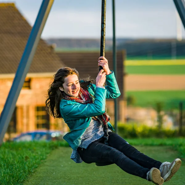 Adolescente menina jogando no parque infantil, à noite — Fotografia de Stock