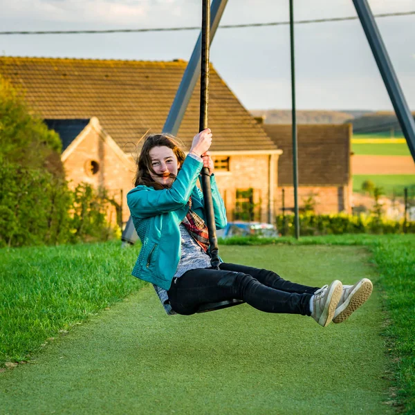 Adolescente jugando en el parque infantil, por la noche — Foto de Stock