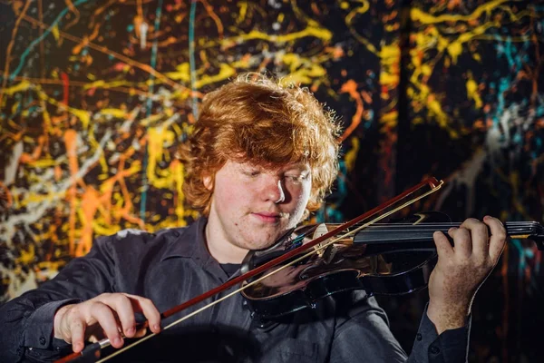 Κοκκινομάλλα φακιδωμένος αγόρι παίζει βιολί με διαφορετικά συναισθήματα o — Φωτογραφία Αρχείου