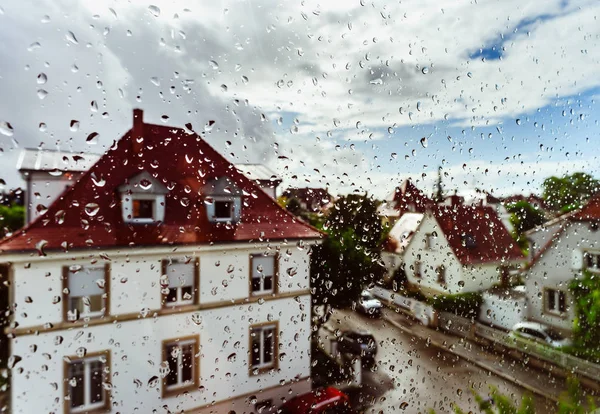 Rainy weather view through the window with water drops on the gl — Stock Photo, Image