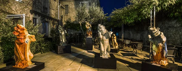 Gotische Monsterskulpturen im sommerlichen Cafégarten, Nachtansicht — Stockfoto