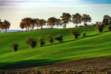 Günbatımı, güzel yeşil ve sarı tepelerde Fransız Tuscany