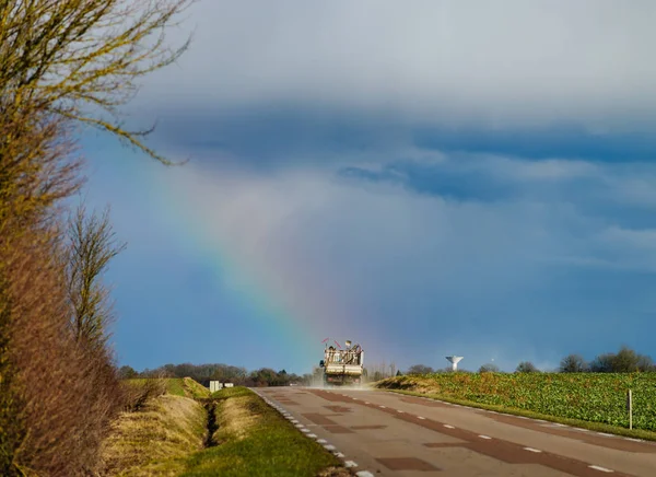 Hermoso arco iris colorido al final de la carretera de asfalto, perspectivas —  Fotos de Stock