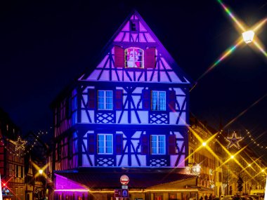 Colmar sokaklarında Noel süsleri. Aydınlatılmış ev.