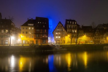 Ile River Embankment in Strasbourg at night, fog. Reflections of