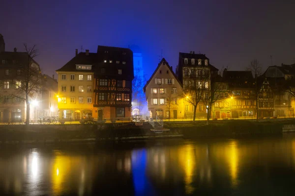 Ile River Embankment in Strasbourg at night, fog. Reflections of — Stok fotoğraf