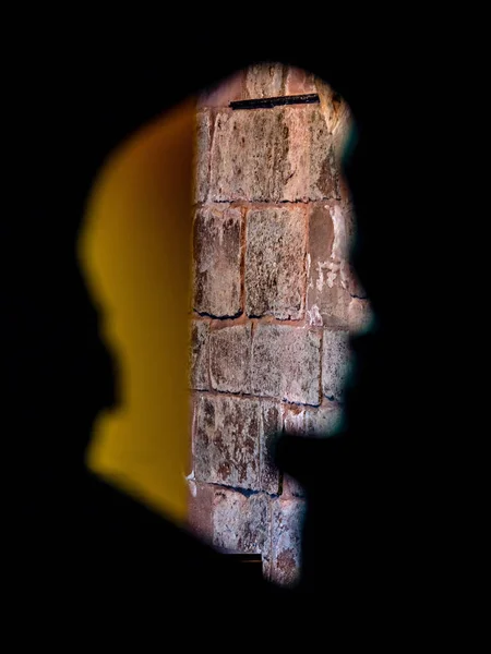 Silhouettes, profils humains sculptés dans le mur à travers lequel vous — Photo