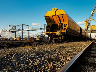 Bright yellow railway freight car against the blue sky in the po