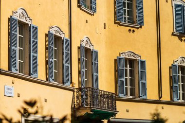 Parlak ve renkli İtalyan şehir manzarası. Günışığı sokakları. Renkli evler. Sıcak ve rahat. Turizm ve seyahat. Deniz, palmiye ağaçları ve tüm pencere ve balkonlarda antik kepenkler..