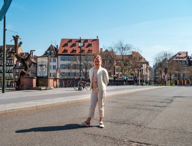 Strasbourg / Fransa: 27 Mart 2020: Karantina zamanı. Coronavirüs salgını. Strazburg 'un boş şehrinde bisikletli bir kız.