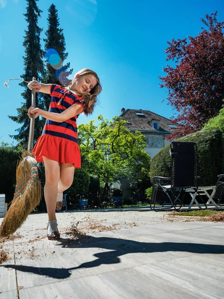 Okullu Bir Kız Elinde Süpürge Annesinin Ayakkabılarıyla Bahçede Poz Veriyor — Stok fotoğraf