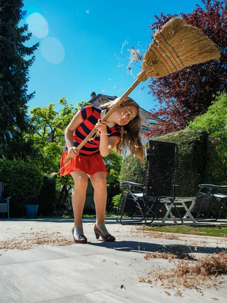 Okullu Bir Kız Elinde Süpürge Annesinin Ayakkabılarıyla Bahçede Poz Veriyor — Stok fotoğraf
