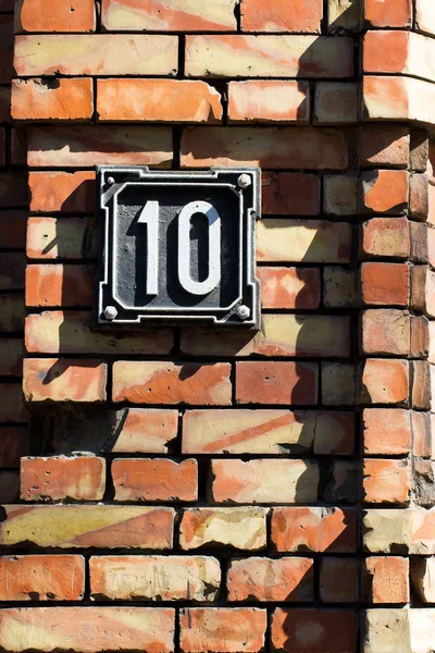 Sinal número dez na antiga parede de tijolos da casa — Fotografia de Stock