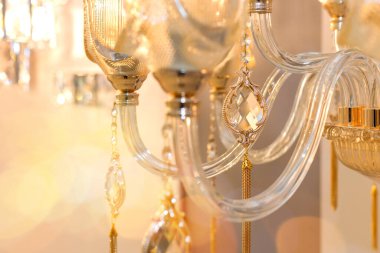 Odadaki tavan avizesinin şeffaf camında asılı duran bir damlanın kristal dekoru. Lüks tasarım kavramı. Kapatın. Yumuşak sıcak filtre, seçici odak.