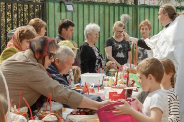 Moskova, Rusya - 27 Nisan 2019: Ortodoks bir rahip Hıristiyanlara kutsal su serpiyor ve geleneksel suyu aydınlatıyor. Gün ışığı.