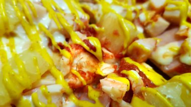 İnce hamurlu, jambonlu, nefis, iştah açıcı tavuk körili pizza masanın üzerinde uzanıyor ve yakından gösteriliyor.
