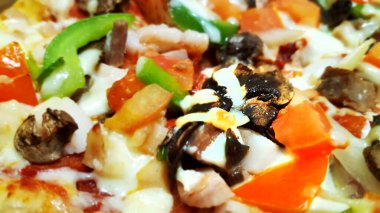 Lokantada pişmiş ağız sulandırıcı muhteşem pizzalar, domuz pastırması, sığır eti, mantar, tavuk, soğan, parmesan peyniri, pepperoni, yeşil biber, taze domates, domuz eti, mozzarella peyniri masada ve yakın çekim gösteriliyor.